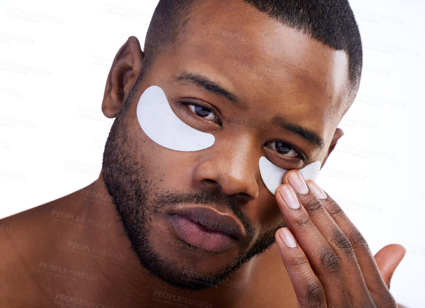 Buy stock photo Studio portrait of a handsome young man wearing under eye patches against a white background