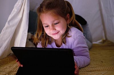 Buy stock photo Shot of an adorable little girl using a digital tablet at night