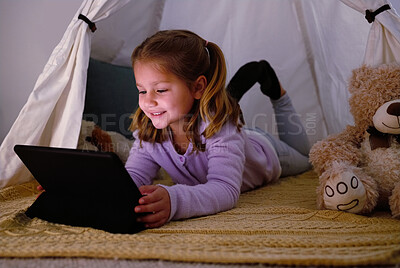 Buy stock photo Shot of an adorable little girl using a digital tablet at night