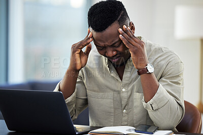 Buy stock photo Shot of a young businessman suffering from a headache while working from home