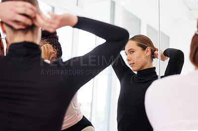Buy stock photo Shot of a young ballerina doing her hair before rehearsal