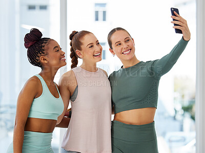Buy stock photo Shot of a diverse group of women standing together after yoga and using a cellphone to take selfies