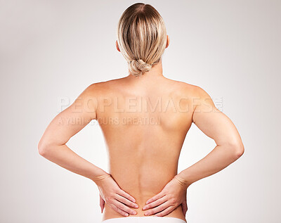 Buy stock photo Studio shot of an unrecognizable young woman posing with her back facing the camera against a grey background