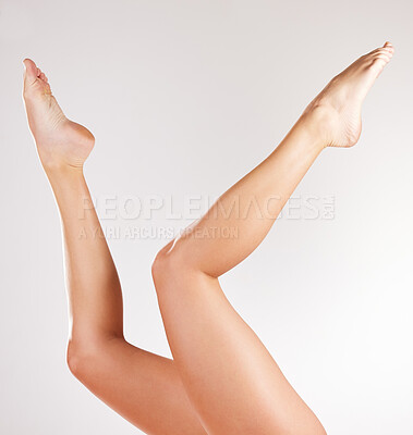 Buy stock photo Studio shot of an unrecognizable young woman posing with her legs in the air against a grey background