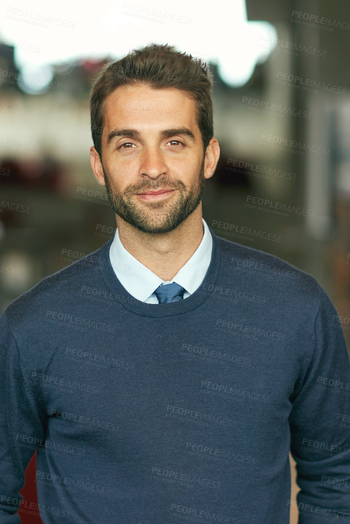 Buy stock photo Cropped portrait of a handsome young businessman standing alone in a library during the day