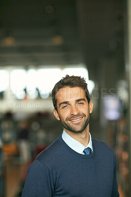 Buy stock photo Cropped portrait of a handsome young businessman standing alone in a library during the day