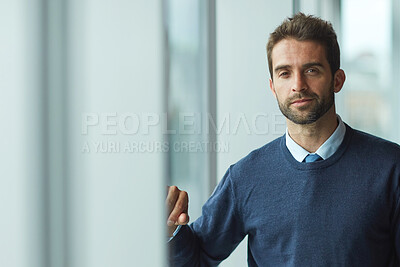 Buy stock photo Cropped portrait of a handsome young businessman standing indoors alone during the day