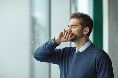 Buy stock photo Cropped shot of a handsome young businessman standing indoors alone and looking stressed