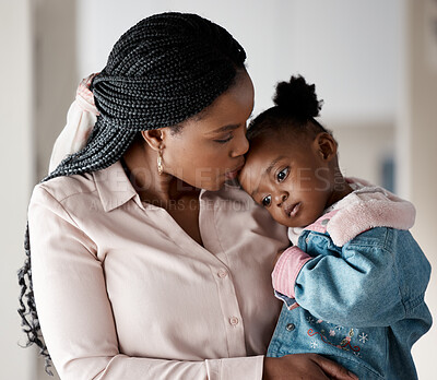 Buy stock photo Shot of a woman holding her daughter while at home