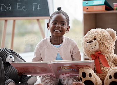 Buy stock photo Shot of an adorable little girl reading a book while sitting at home