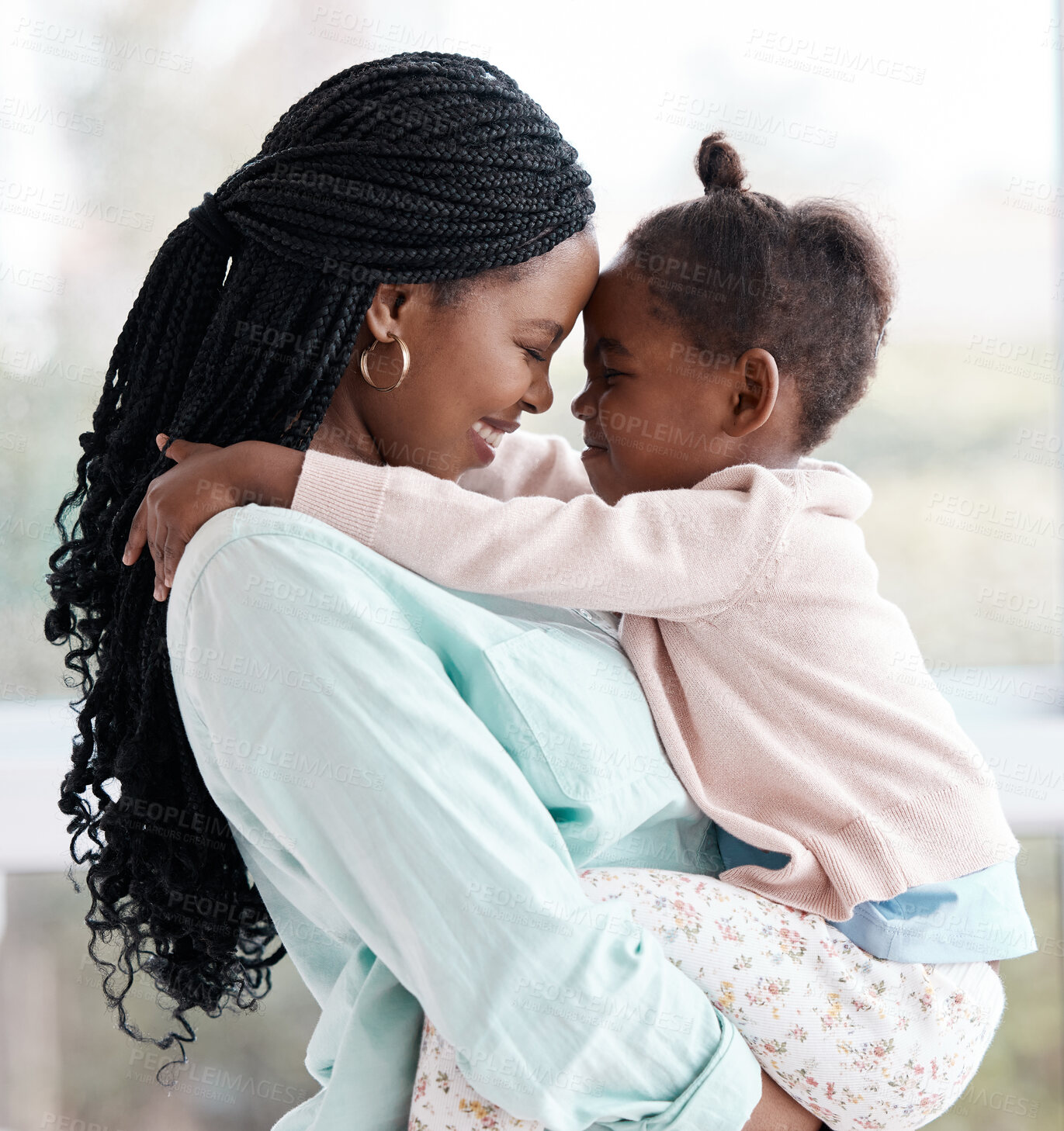 Buy stock photo Shot of a woman holding her daughter while at home