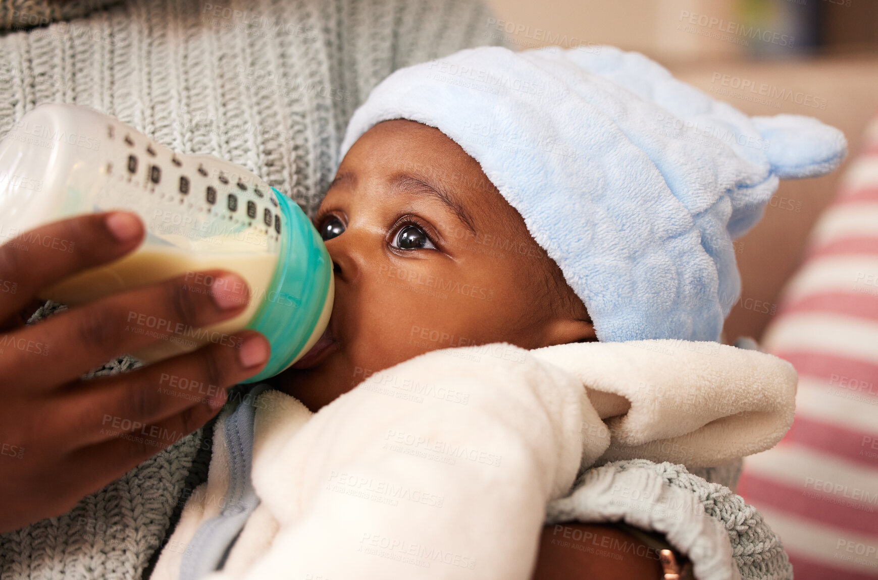 Buy stock photo Shot of an adorable baby girl being bottle fed by her mother at home