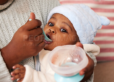 Buy stock photo Black mother, baby and feeding with spoon for meal, nutrition or healthy snack at home. Closeup of African mom holding cute or adorable infant eating food in parenting or nursing young child at house