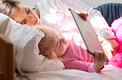 Buy stock photo Shot of a young mother and her daughter using a digital tablet together at home