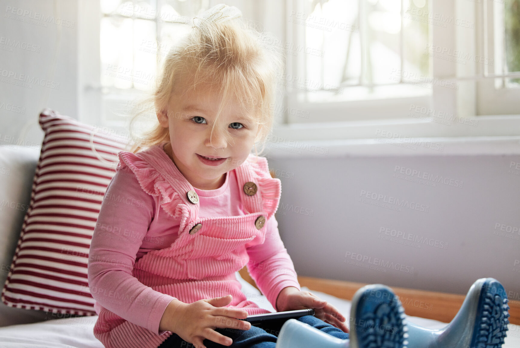 Buy stock photo Shot of a little girl using a phone at home
