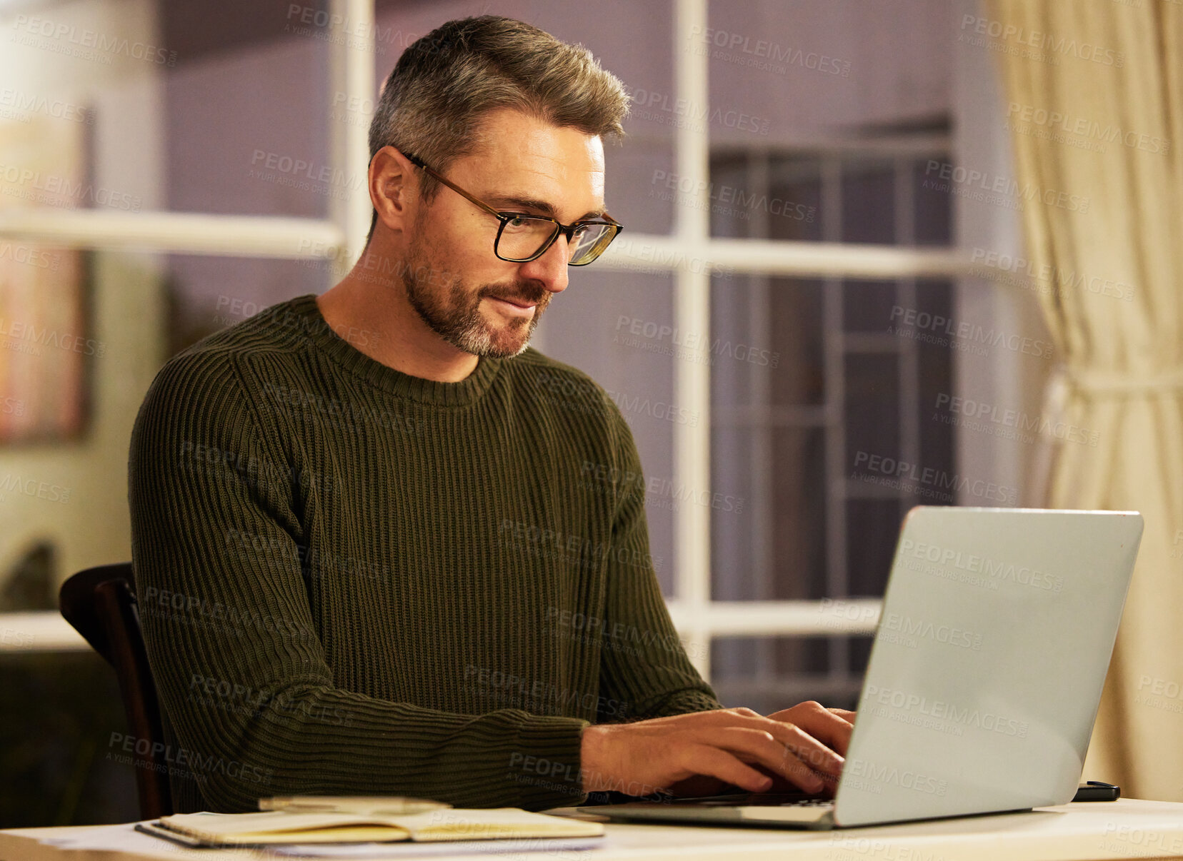 Buy stock photo Cropped shot of a handsome mature businessman working on his laptop at home