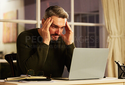 Buy stock photo Cropped shot of a handsome mature businessman looking stressed while working on his laptop at home