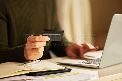 Buy stock photo Cropped shot of an unrecognizable businessman holding his credit card while working on a laptop at home
