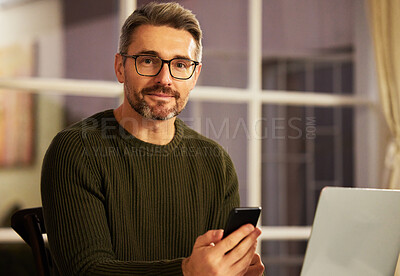Buy stock photo Cropped portrait of a handsome mature businessman sending a text while working on his laptop at home