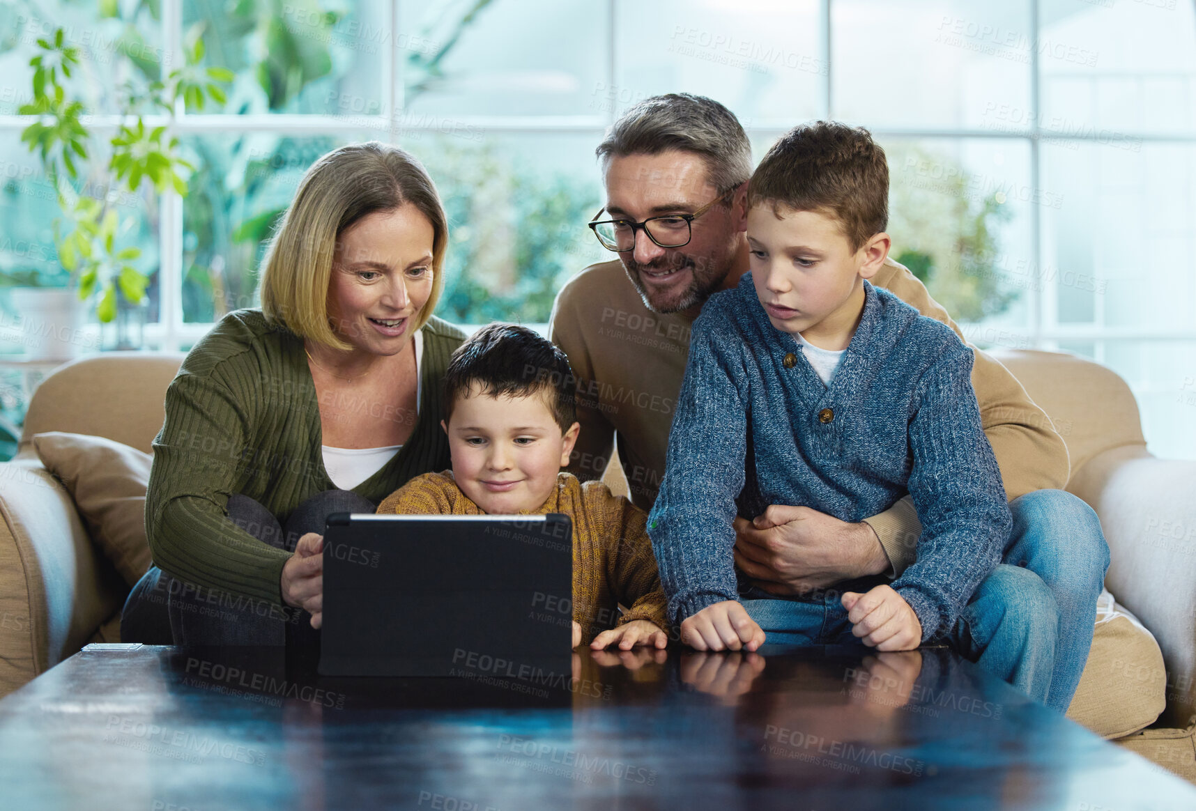 Buy stock photo Shot of a family using a digital tablet together