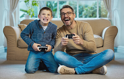 Buy stock photo Shot of a father and son playing games together