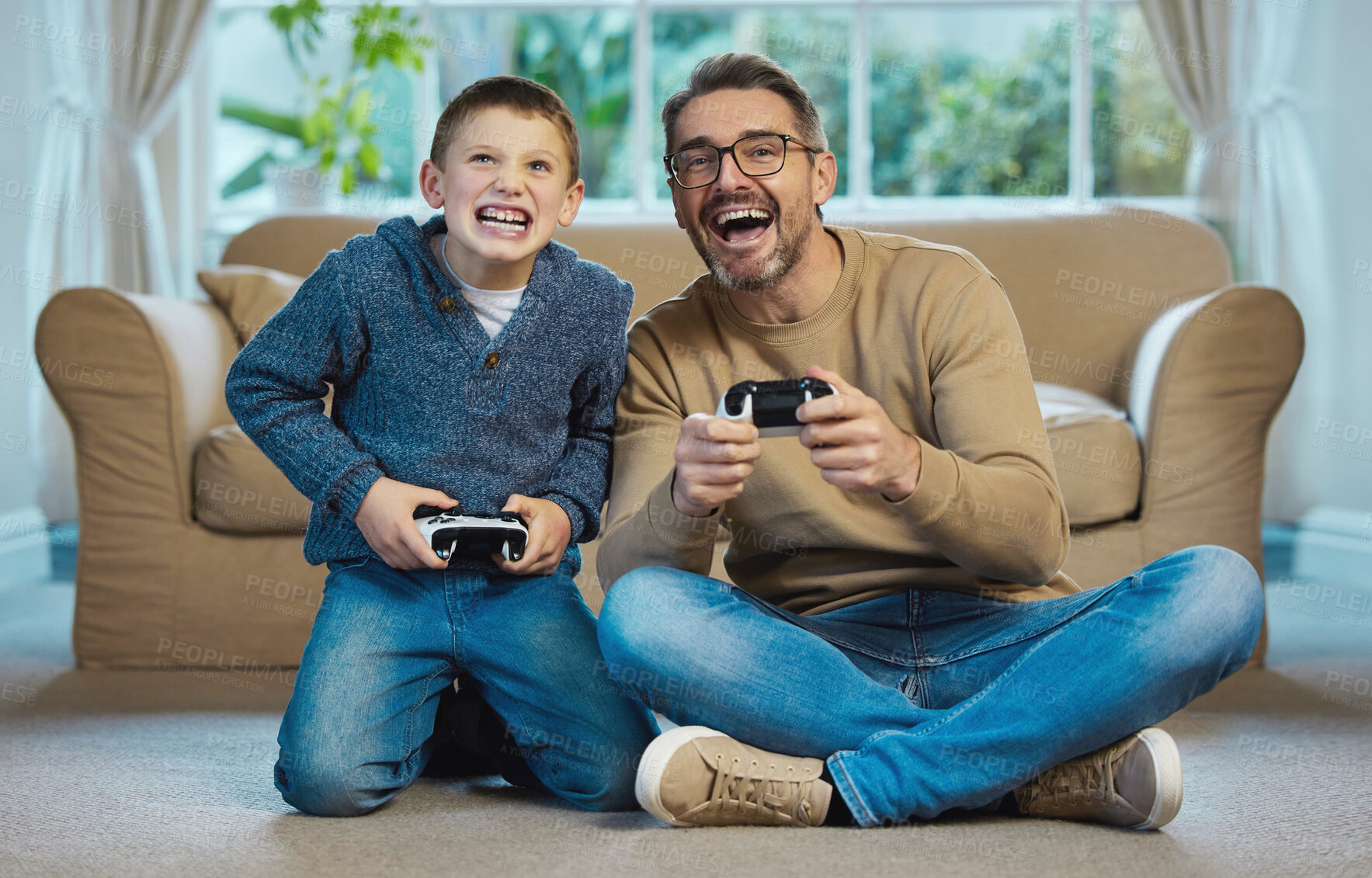 Buy stock photo Shot of a father and son playing games together