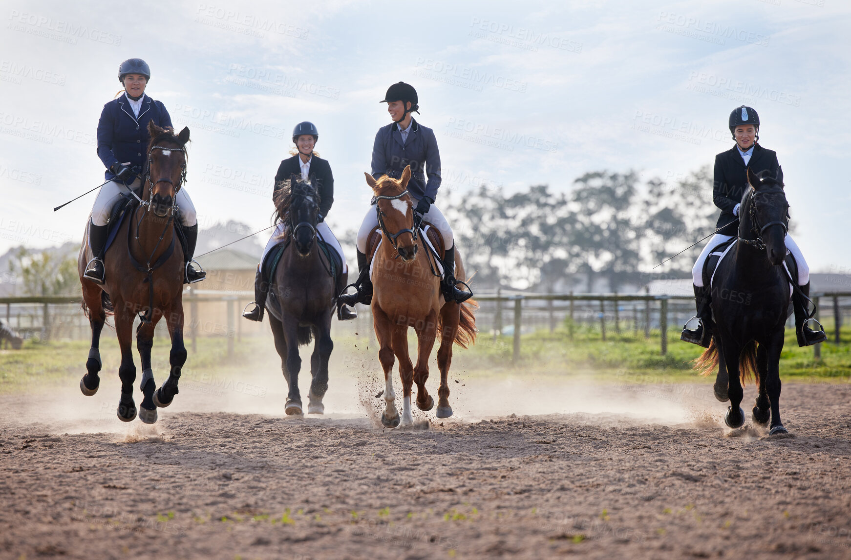 Buy stock photo Full length shot of a group of attractive young female jockeys riding their horses out on the farm