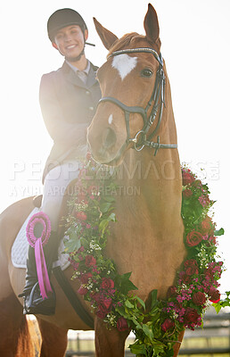 Buy stock photo Cropped shot of an attractive young female jockey sitting on her horse's back in the winner's circle