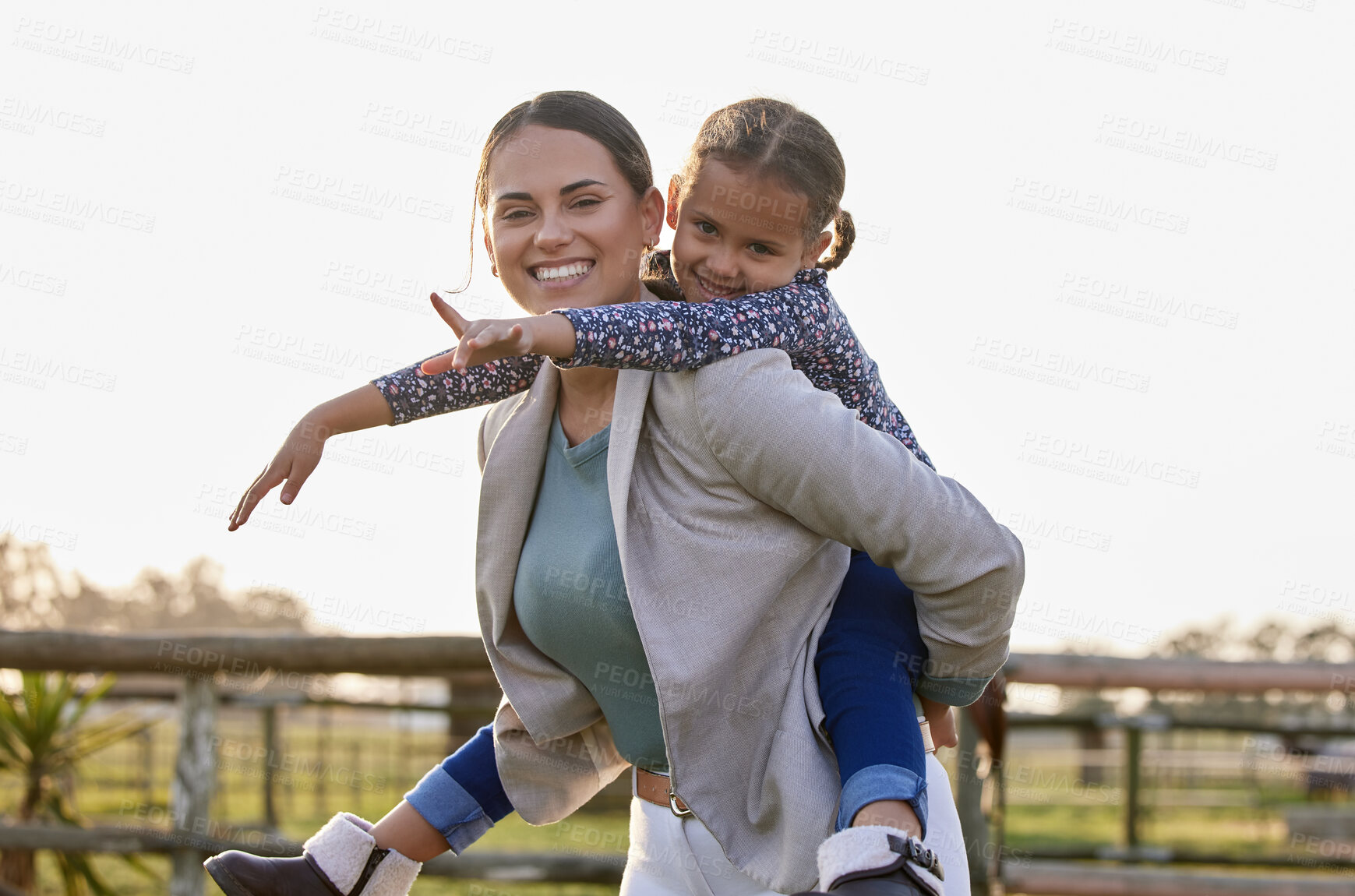 Buy stock photo Shot of an adorable little girl enjoying a piggyback ride with her mother on her farm