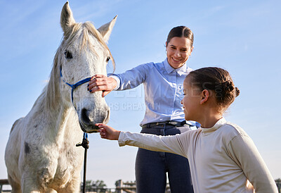 Buy stock photo Cropped shot of an attractive young woman and her daughter petting a horse outside on the ranch
