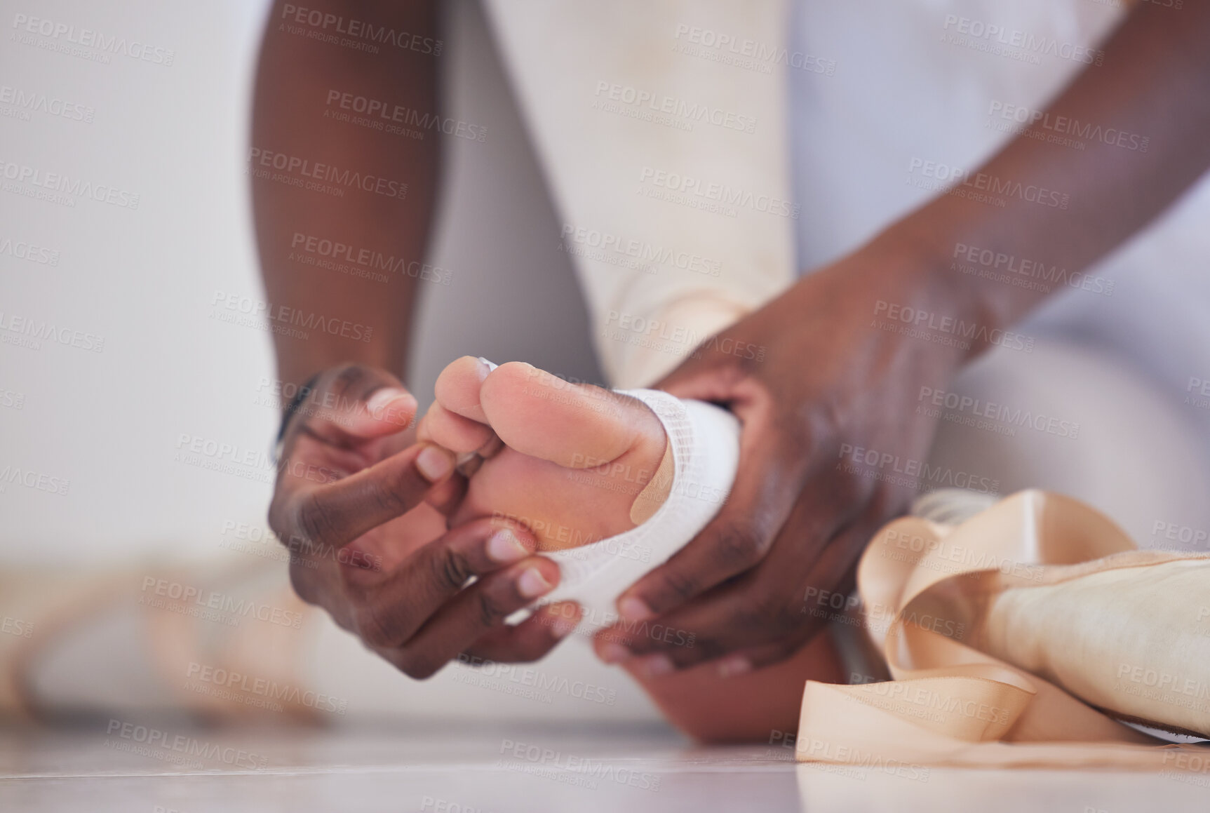 Buy stock photo Shot of an unrecognizable  ballet dancer tying on her pointe shoes
