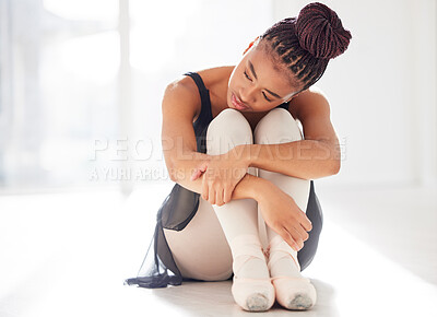 Buy stock photo Shot of a ballerina looking sad while sitting in her dance studio