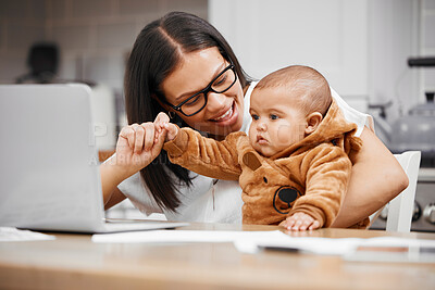 Buy stock photo Shot of a young mother using a laptop while playing with her son at home