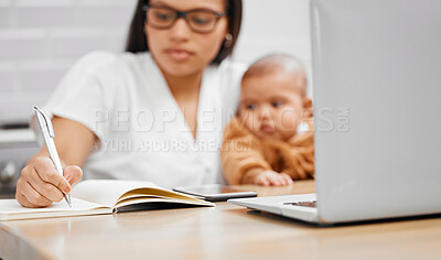 Buy stock photo Shot of a young mother writing in a notebook while holding her son at home
