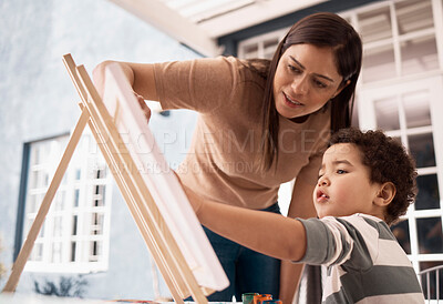 Buy stock photo Shot of a little boy painting on a canvas with his mother