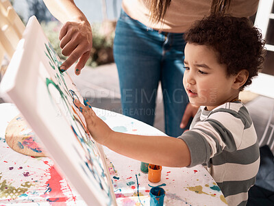 Buy stock photo Shot of a little boy painting on a canvas with his mother