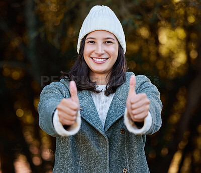 Buy stock photo Shot of an attractive young woman standing alone outside and showing a thumbs up