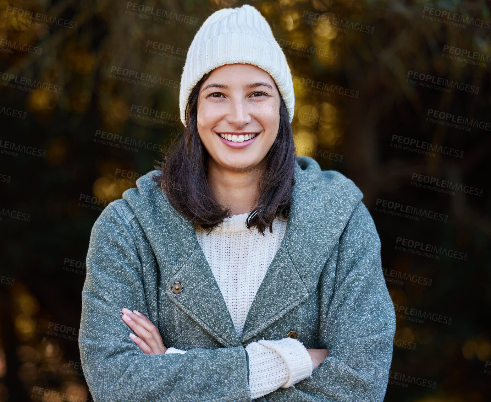 Buy stock photo Shot of an attractive young woman standing alone outside with her arms folded