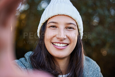 Buy stock photo Shot of an attractive young woman standing alone outside and taking a selfie