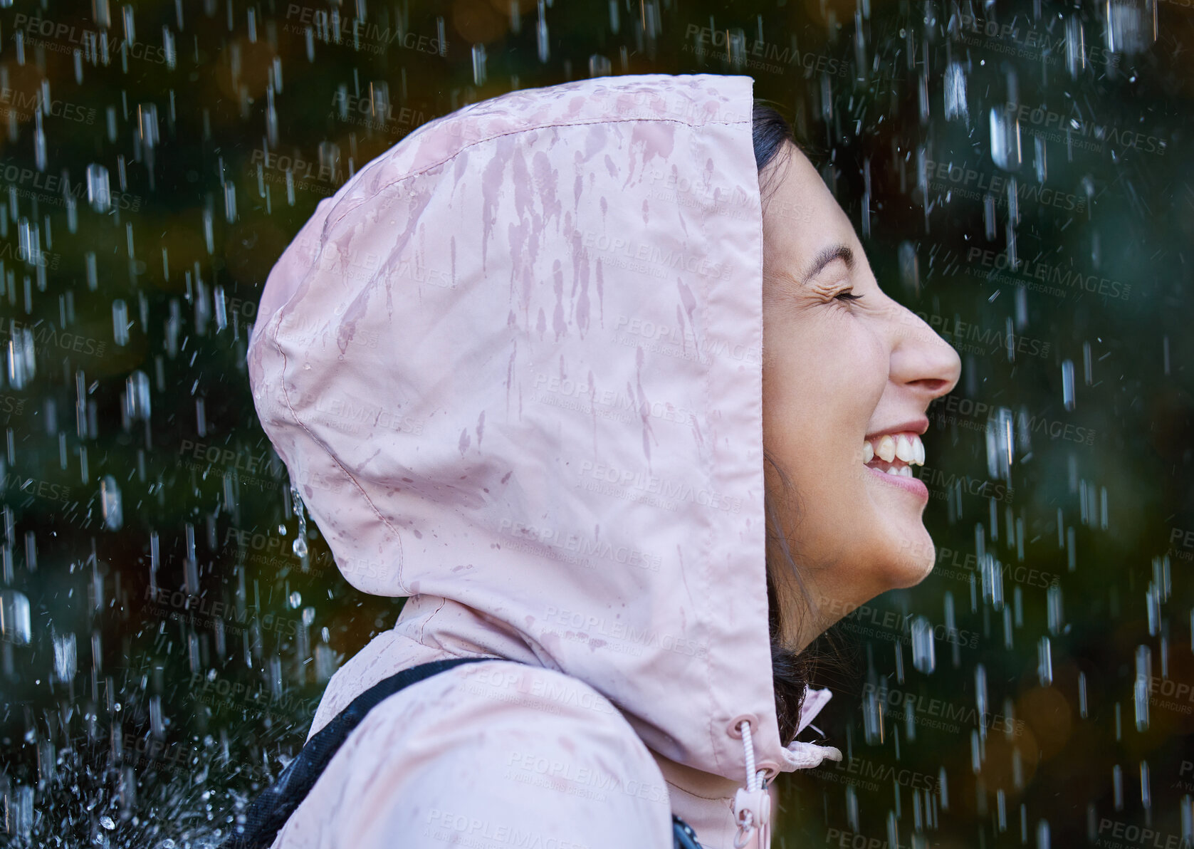 Buy stock photo Shot of an attractive young woman standing alone outside in the rain