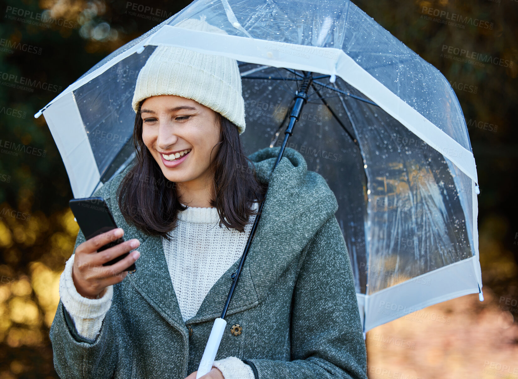 Buy stock photo Rain, umbrella and girl with phone in a park for social media, search or web communication on morning trip. Storm, cover and happy woman with smartphone for taxi, travel and map, direction or guide