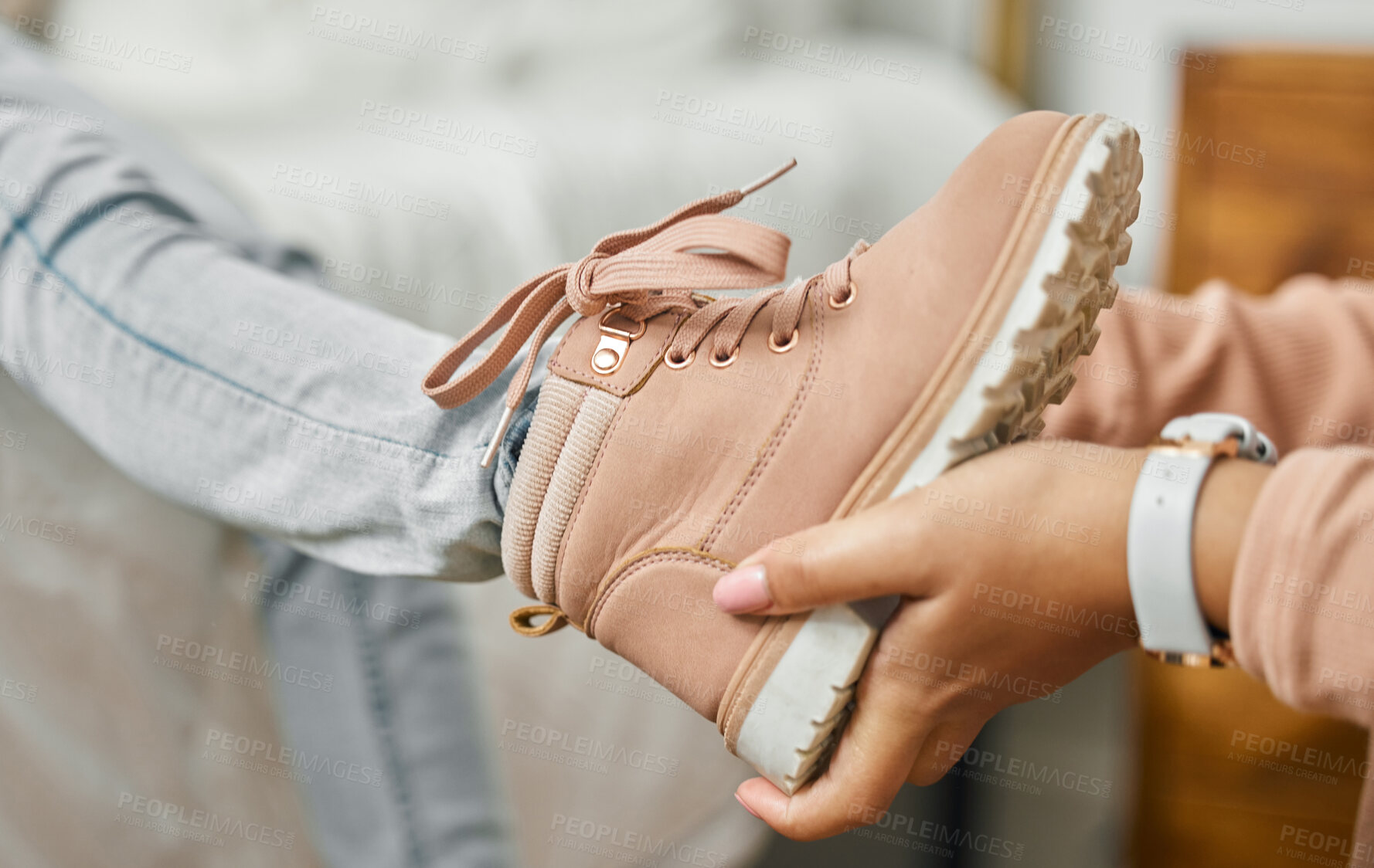 Buy stock photo Shot of an unrecognizable person putting a shoe onto a child's foot at home