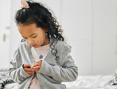 Buy stock photo Shot of a little girl getting dressed at home