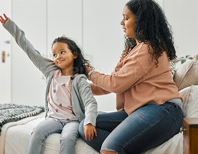 Buy stock photo Shot of a young mother brushing her daughter's hair at home