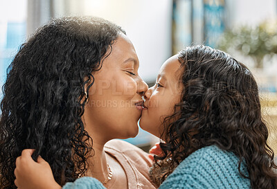 Buy stock photo Shot of an adorable little girl giving her mother kiss while bonding with her in the living room at home