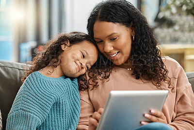 Buy stock photo Shot of an attractive young woman sitting and bonding with her daughter while using a digital tablet