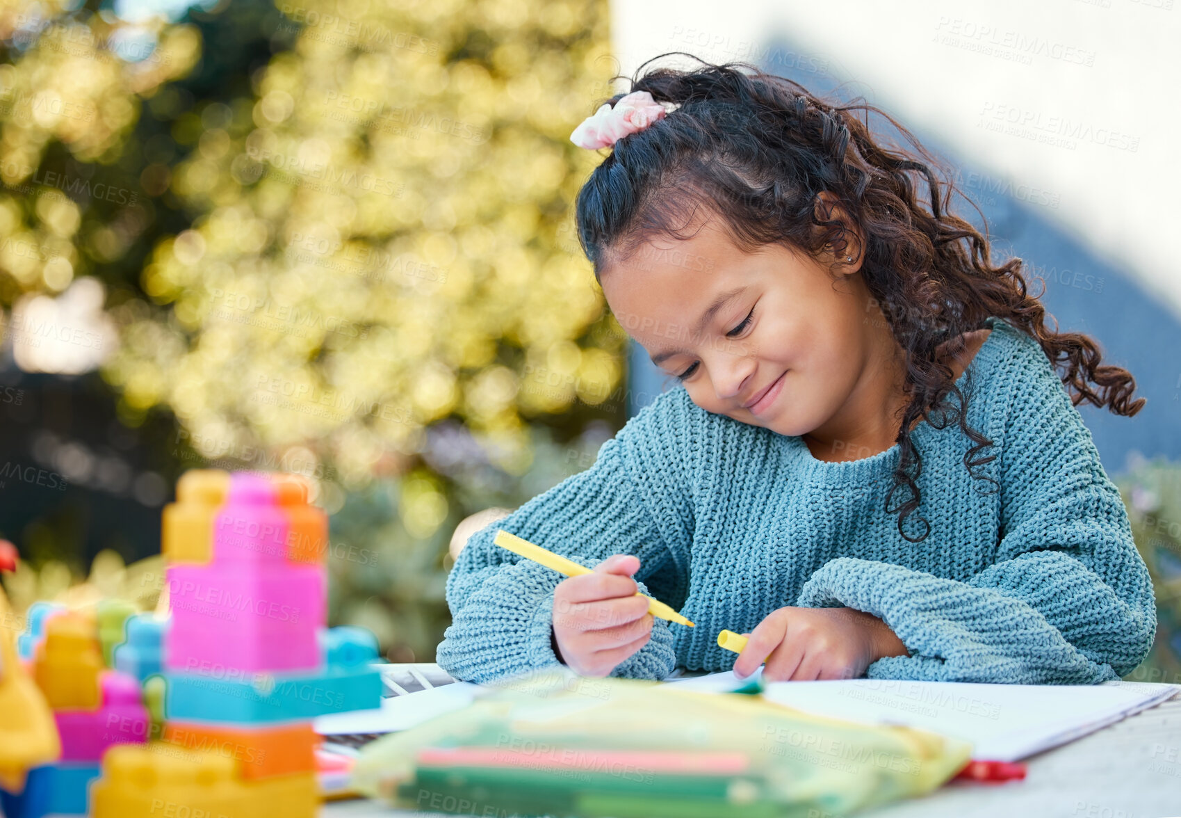 Buy stock photo Shot of a little girl completing homework in her yard
