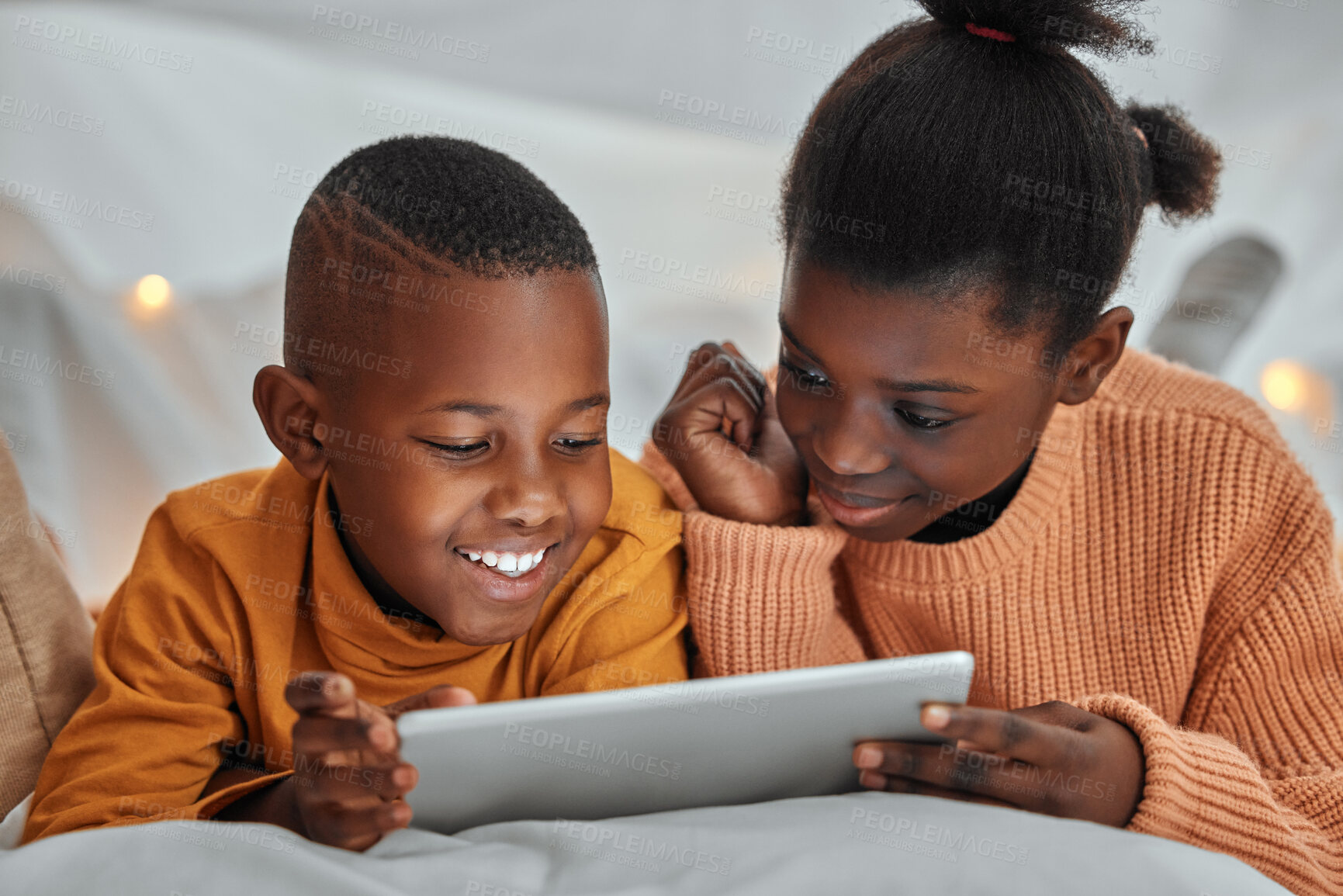 Buy stock photo Shot of a brother and sister using a digital tablet together at home