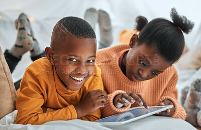 Buy stock photo Portrait of a young boy using a digital tablet with his sister at home