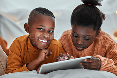 Buy stock photo Portrait of a young boy using a digital tablet with his sister at home